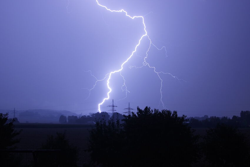 Blitzeinschlag in ein Waldareal bei Dämmerung